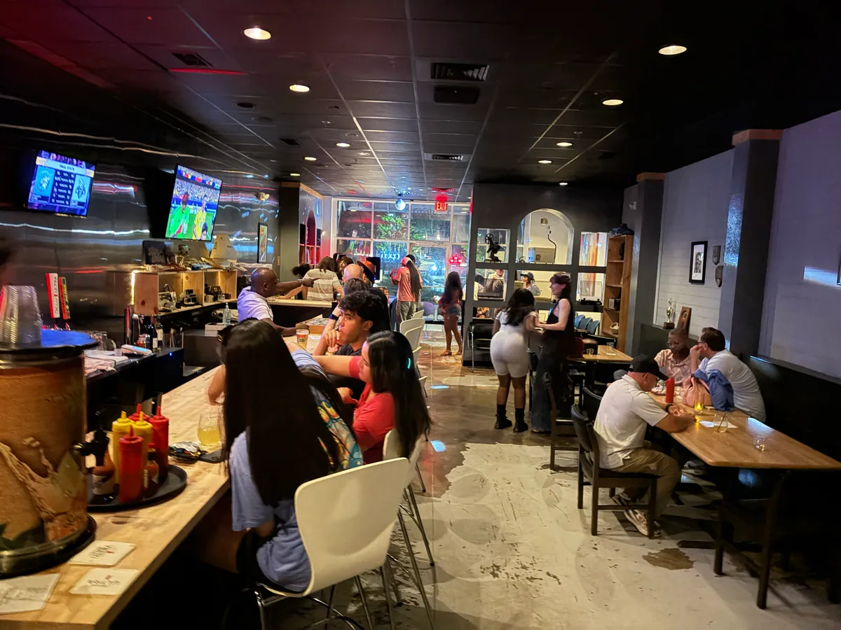 A full room, guests along the bar and at the tables