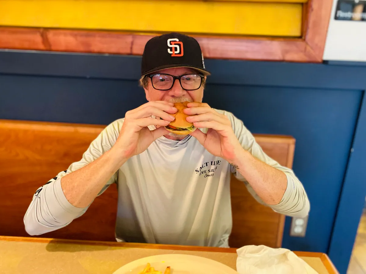 A guest mid-burger in a booth